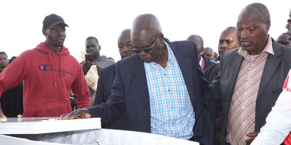 Francis Kigen uri hagati ,ubwo yarebaga umurambo w'umwana we ukigezwa ku kibuga cy'indege